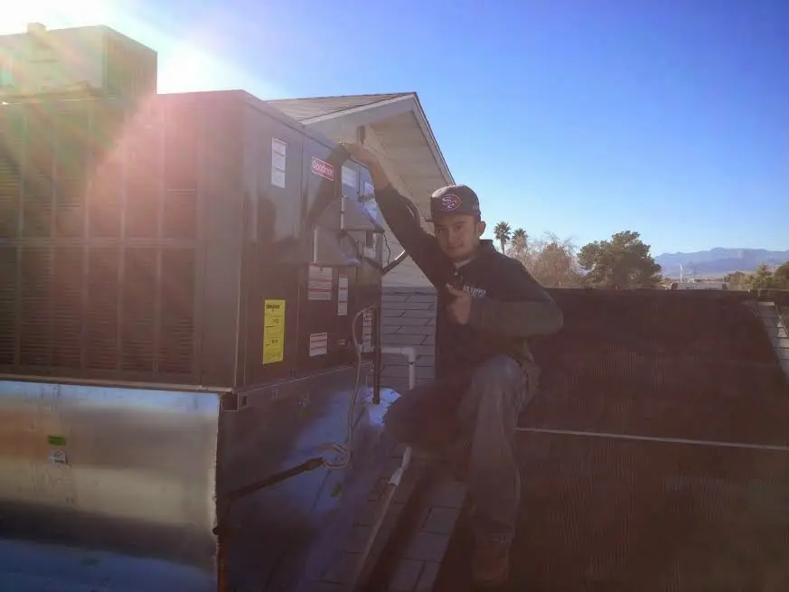 HVAC technician performing Air Duct Repair on a rooftop unit in Santa Clara